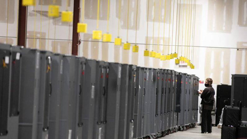 Un observador electoral del Partido Republicano de Georgia observa los transportadores de máquinas de votación que están almacenados en el Centro de Preparación de Elecciones del Condado de Fulton en Atlanta, Georgia, el 4 de noviembre de 2020. (Jessica McGowan/Getty Images)