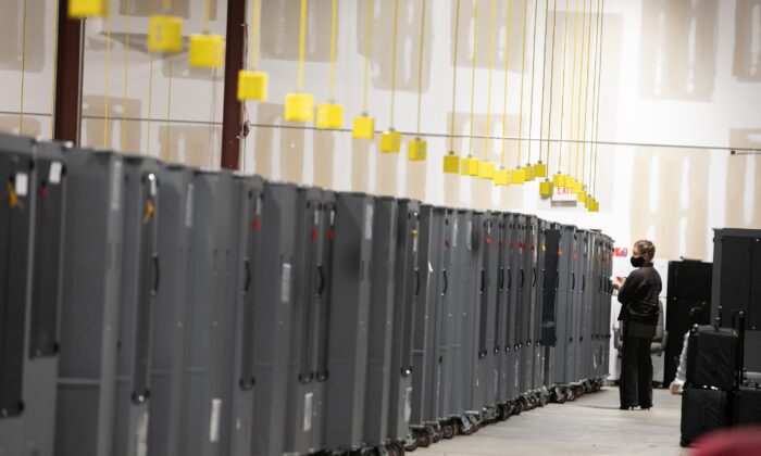 Un observador electoral del Partido Republicano de Georgia observa los transportadores de máquinas de votación que están almacenados en el Centro de Preparación de Elecciones del Condado de Fulton en Atlanta, Georgia, el 4 de noviembre de 2020. (Jessica McGowan/Getty Images)