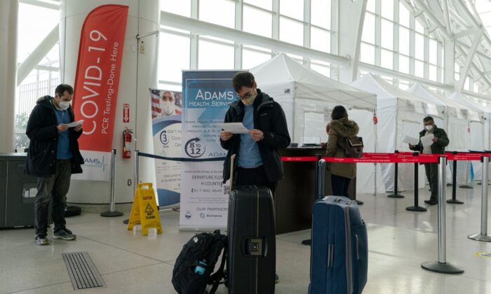Unos viajeros miran los resultados de sus tests de COVID-19 tras realizarse la prueba dentro del aeropuerto internacional JFK de Nueva York el 22 de diciembre de 2020. (Kena Betancur/AFP vía Getty Images)