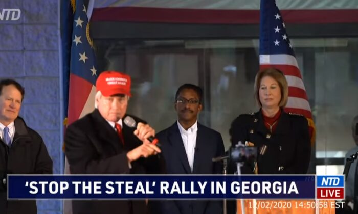 Lin Wood habla en el mitin "Stop the Steal" (Detengan el robo), mientras el organizador Ali Alexander, tercero desde la derecha, y Sidney Powell observan, en Atlanta, Georgia, el 2 de diciembre de 2020. (NTD)
