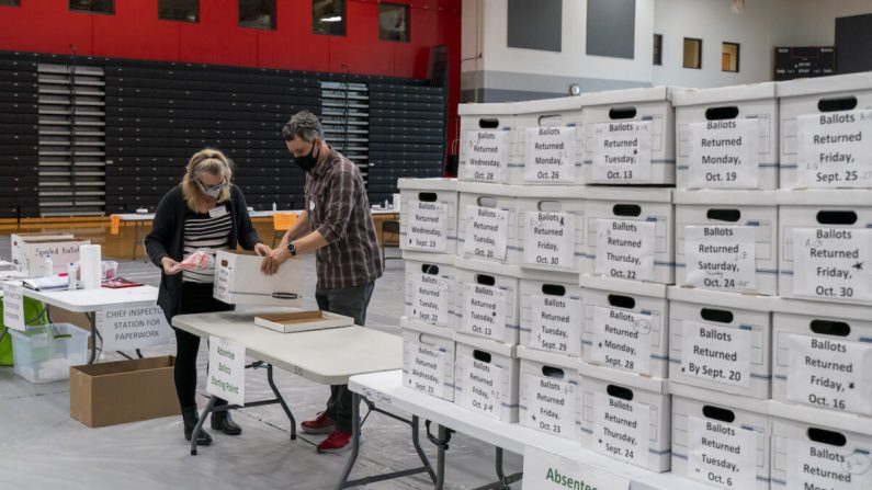 Trabajadores electorales registran una caja de boletas de ausente en la Escuela Secundaria Sun Prairie en Sun Prairie, Wisconsin, el 3 de noviembre de 2020. (Andy Manis/Getty Images)
