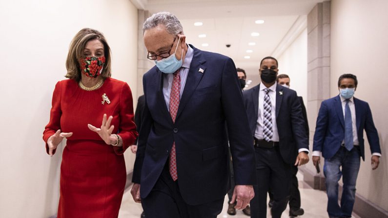 La presidenta de la Cámara de Representantes, Nancy Pelosi (D-Calif.), izquierda, y el líder de la minoría del Senado, Chuck Schumer (D-N.Y.), caminan por el Capitolio de Washington el 20 de diciembre de 2020. (Tasos Katopodis/Getty Images)