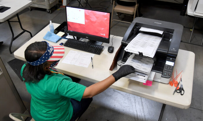 Un trabajador electoral del condado de Clark escanea las boletas de voto por correo en el Departamento de Elecciones del condado de Clark en North Las Vegas, Nev., el 7 de noviembre de 2020. (Ethan Miller/Getty Images)