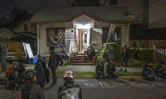La gente se reúne fuera de una casa donde una familia iba a ser desalojada, dentro de una llamada zona autónoma, en Portland, Oregon, el 9 de diciembre de 2020. (Nathan Howard/Getty Images)