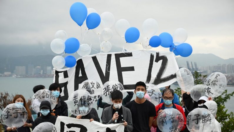 Cuatro familias y miembros del grupo de la campaña Save12HKers se preparan para lanzar globos hacia Yantian, en China continental (atrás) en la Isla Crooked, en Hong Kong, el 21 de noviembre de 2020. (Peter Parks/AFP vía Getty Images)
