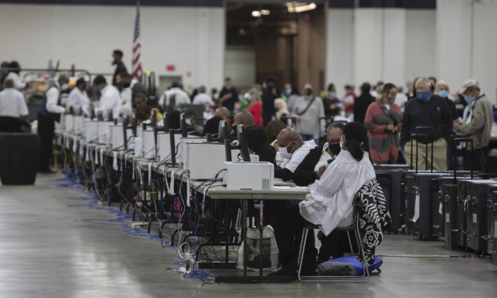 Trabajadores del Departamento de Elecciones de Detroit ayudan a procesar las boletas de ausentes en la Junta Central de Conteo en el Centro TCF en Detroit, Michigan, el 4 de noviembre de 2020. (Elaine Cromie/Getty Images)