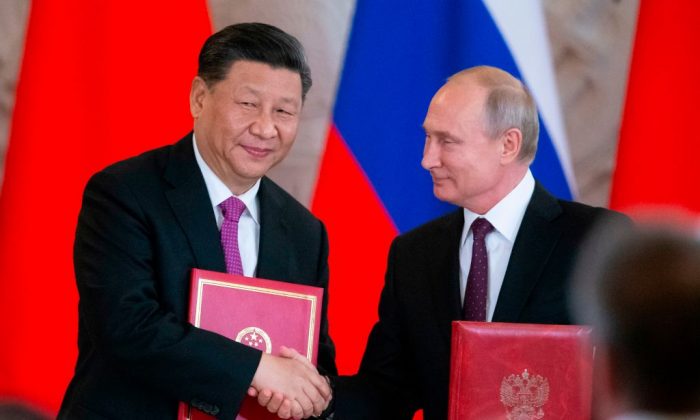El presidente ruso, Vladimir Putin, y su homólogo chino, Xi Jinping, intercambian documentos durante una ceremonia de firma tras sus conversaciones en el Kremlin, en Moscú, el 5 de junio de 2019. (Alexander Zemlianichenko/AFP/Getty Images)