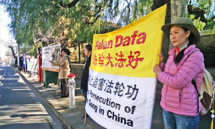 Angel sostiene una pancarta que dice "detengan la persecución a Falun Dafa en China" frente a la entrada principal del consulado chino en Toorak, en Melbourne, Australia. (Cortesía de Ángel)