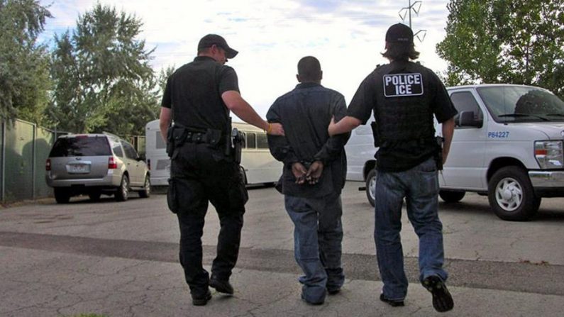 Fotografía cedida en la que aparecen dos agentes del Servicio de Inmigración y Aduanas (ICE, en inglés) llevando un inmigrante indocumentado. EFE/ICE