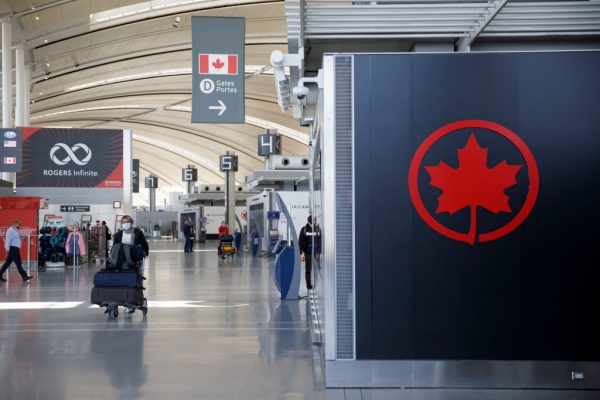 Una pasajera lleva su equipaje cerca de un logotipo de Air Canada en el Aeropuerto Internacional Toronto Pearson el 1 de abril de 2020 en Toronto, Canadá. (Foto de Cole Burston / Getty Images)