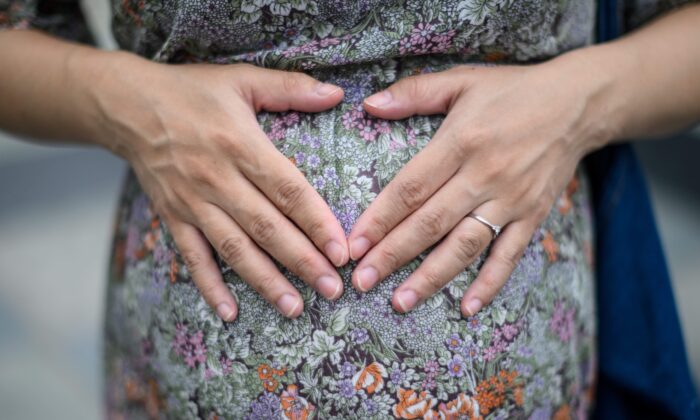 Una madre en embarazo apoya sus manos sobre su panza, en Hong Kong, el 31 de marzo de 2020. (Anthony Wallace/AFP a través de Getty Images)