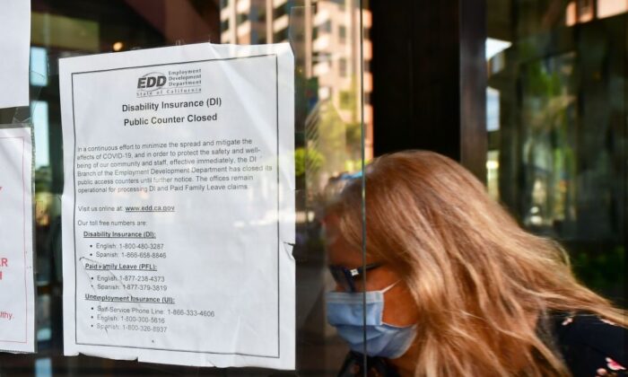Una mujer con mascarilla entra en el edificio de Los Ángeles, donde se encuentran las oficinas del Departamento de Desarrollo de Empleo (EDD), el 4 de mayo de 2020. (Frederic J. Brown/AFP vía Getty Images)