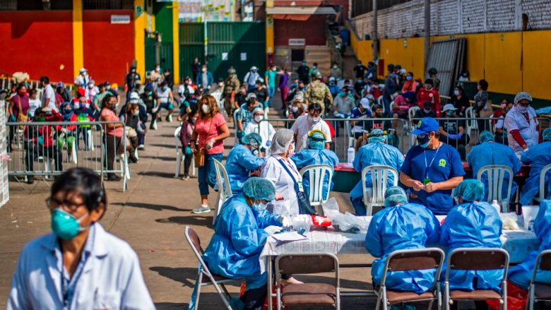 Trabajadores del Ministerio de la salud se preparan para probar a los empleados del mercado de Ciudad de Dios para descartar COVID-19 en Lima, Perú, el 11 de mayo de 2020 (Foto de Ernesto Benavides / AFP vía Getty Images)