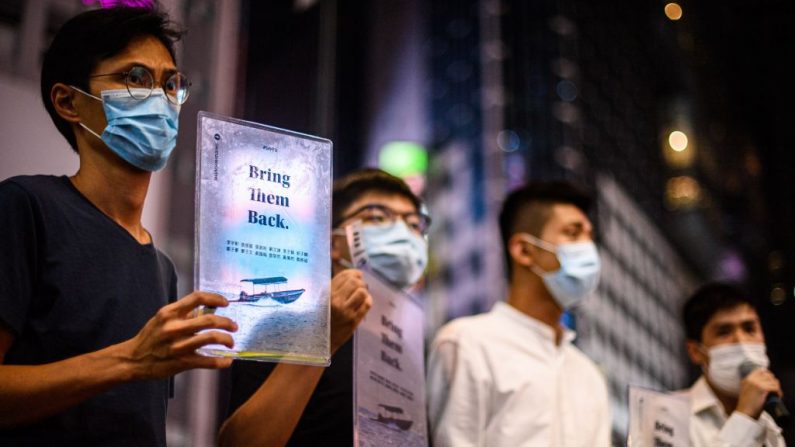 Los activistas prodemocracia de Hong Kong, Eddie Chu, Joshua Wong, Owen Chow y Lester Shum sostienen carteles el 20 de octubre de 2020, en apoyo de los 12 activistas locales detenidos en China continental, después de que la guardia costera interceptara un barco que los transportaba a Taiwán a fines de agosto. (Foto de Anthony Wallace/AFP vía Getty Images)