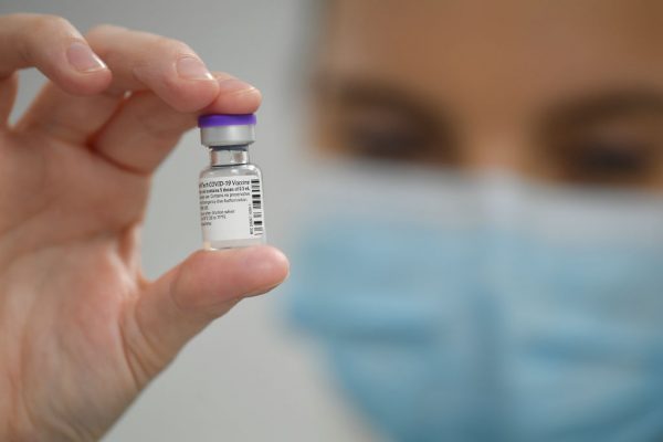 Un miembro del personal posa con un frasco de la vacuna covid-19 de Pfizer-BioNTech. (Justin Tallis - Pool / Getty Images)