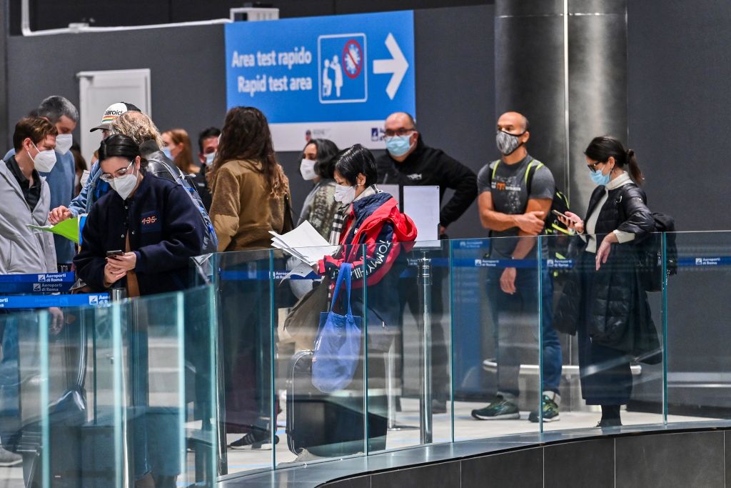 Los pasajeros que acaban de aterrizar en un vuelo de Alitalia esperan en la fila mientras se preparan para someterse a una prueba rápida con hisopo de antígeno para COVID-19 el 9 de diciembre de 2020 en un Área de Prueba Rápida establecida en el aeropuerto de Fiumicino de Roma, Italia. (Foto de ANDREAS SOLARO / AFP a través de Getty Images)