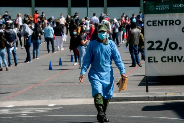 Trabajadores de la salud hacen cola para recibir la vacuna Pfizer / BioNTech COVID-19, en el Batallón 22 del Hospital de la Policía Militar en la Ciudad de México (México), el 30 de diciembre de 2020. (Foto de PEDRO PARDO / AFP a través de Getty Images)