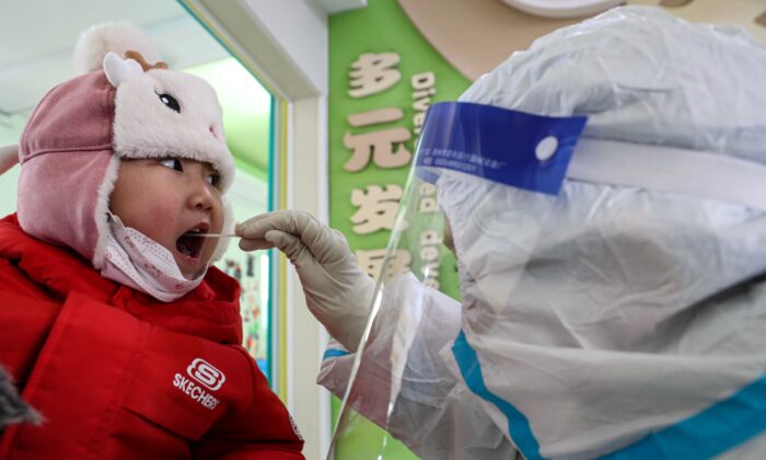 Un niño toma una prueba de hisopo COVID-19 en Shenyang, China, el 1 de enero de 2021. (STR/AFP a través de Getty Images)