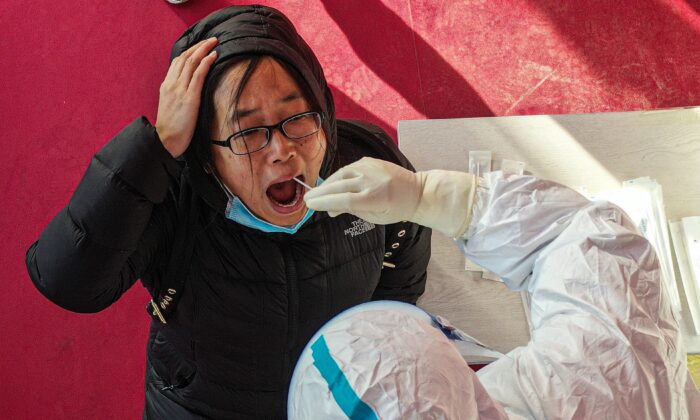 Un trabajador de salud toma una muestra de hisopo de un residente para una prueba de COVID-19 en Shenyang, China, el 2 de enero de 2021 (STR / AFP a través de Getty Images).