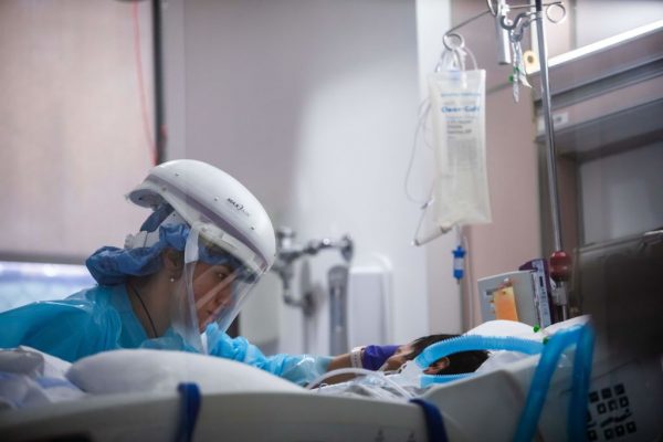Una enfermera usa equipo de protección personal (PPE) mientras atiende a un paciente con covid-19 en la Unidad de Cuidados Intensivos (UCI) del Centro Médico Providence Cedars-Sinai Tarzana en Tarzana, California, EE.UU., el 3 de enero de 2021. (Foto de APU GOMES / AFP a través de Getty Images)