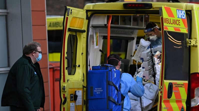 Un paramédico que vestía un equipo de protección personal completo descarga a un paciente de una ambulancia frente al Royal London Hospital en el este de Londres (Reino Unido) el 6 de enero de 2021. (Foto de DANIEL LEAL-OLIVAS / AFP vía Getty Images)