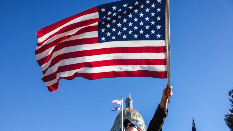 El partidario de Donald Trump, Travis Yost, ondea una bandera mientras protesta por las elecciones frente al Capitolio del Estado de Colorado el 6 de enero de 2021 en Denver, Colorado. (Michael Ciaglo/Getty Images)