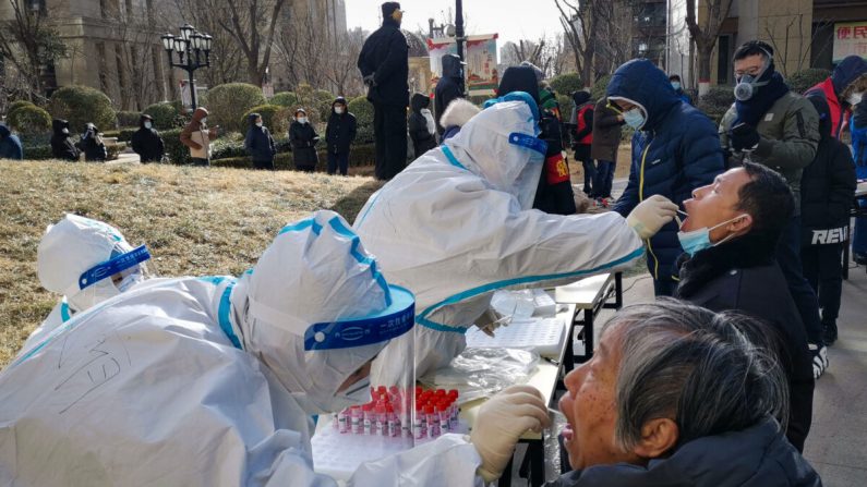 Trabajadores médicos toman muestras de hisopos de residentes en Shijiazhuang, en la provincia de Hebei, en el norte de China, el 6 de enero de 2021. (STR/CNS/AFP a través de Getty Images)