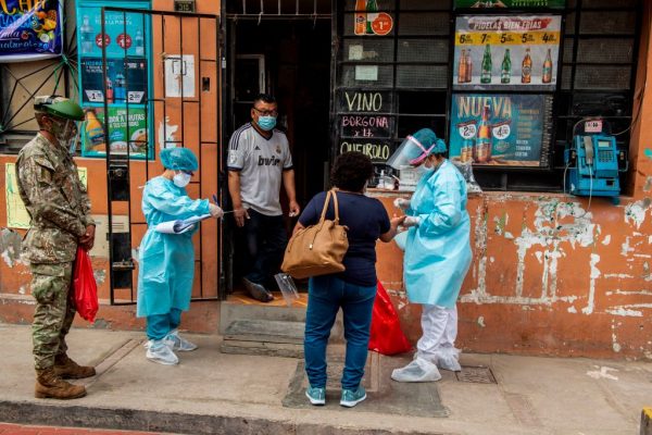 Personal del Ministerio de Salud peruano examina y realiza pruebas para descartar COVID-19 en personas mayores de 60 años en sus casas en el distrito El Agustino, al este de Lima (Perú) el 07 de enero de 2021. (Foto de ERNESTO BENAVIDES / AFP a través de Getty Images)