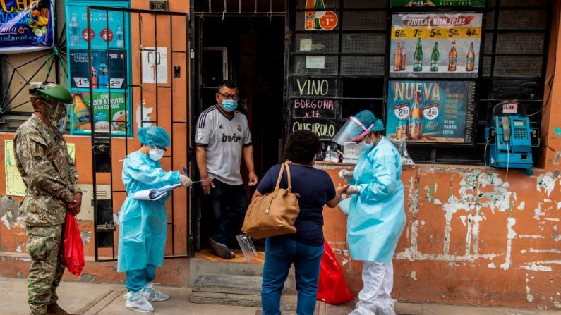 Personal del Ministerio de Salud peruano examina y realiza pruebas para descartar COVID-19 en personas mayores de 60 años en sus casas en el distrito El Agustino, al este de Lima (Perú) el 07 de enero de 2021. (Foto de ERNESTO BENAVIDES / AFP a través de Getty Images)
