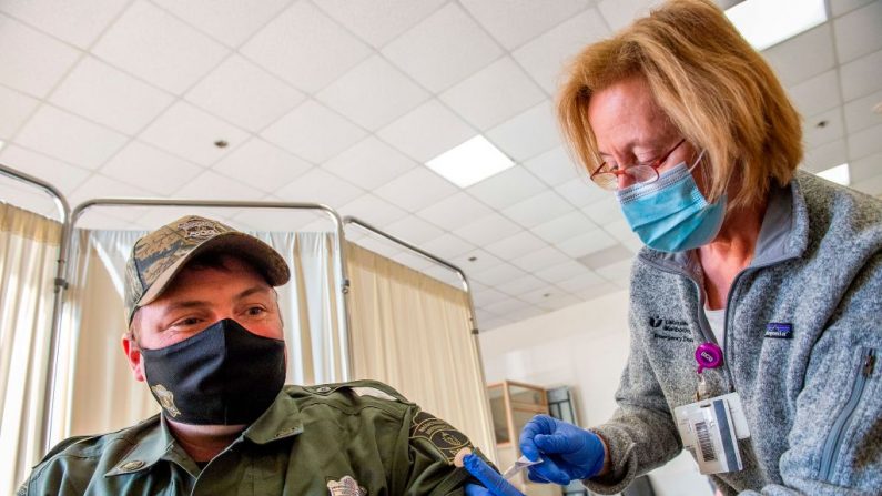Una enfermera aplica la vacuna contra el COVID-19  de Moderna a un oficial de policía en el Hospital UMass Memorial de Marlborough, Massachusetts, el 12 de enero de 2021. (Joseph Prezioso/AFP vía Getty Images)