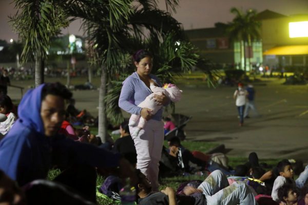 Madre con bebé en brazos esperan la caravana migrante en la estación de autobuses el 14 de enero de 2021 en San Pedro Sula, Honduras. (Foto de Milo Espinoza / Getty Images)