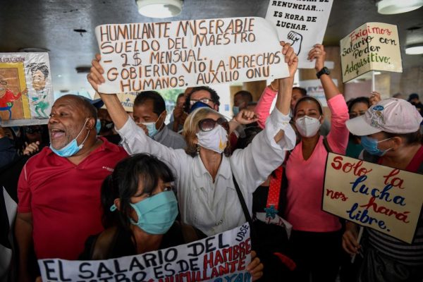 Maestros venezolanos gritan consignas durante una manifestación exigiendo al régimen de Maduro mejoras salariales en el Día del Maestro frente al Ministerio de Trabajo, en Caracas, Venezuela, el 15 de enero de 2021. (Foto de Federico Parra / AFP vía Getty Images)