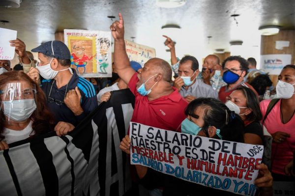 Maestros venezolanos gritan consignas durante una manifestación exigiendo al régimen de Maduro mejoras salariales en el Día del Maestro frente al Ministerio de Trabajo, en Caracas, Venezuela, el 15 de enero de 2021. (Foto de Federico Parra / AFP vía Getty Images)