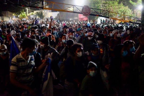 Miles de migrantes hondureños atraviesan la valla policial mientras intentan cruzar la frontera en El Florido en Guatemala formando la primera caravana migrante del año en su camino a los Estados Unidos el 15 de enero de 2021. (Foto de Johan Ordonez / AFP a través de Getty Images)