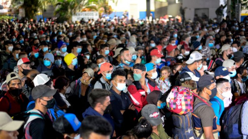 Miles de migrantes hondureños atraviesan la valla policial mientras intentan cruzar la frontera en El Florido en Guatemala formando la primera caravana migrante del año en su camino a los Estados Unidos el 15 de enero de 2021. (Foto de JOHAN ORDONEZ / AFP a través de Getty Images)