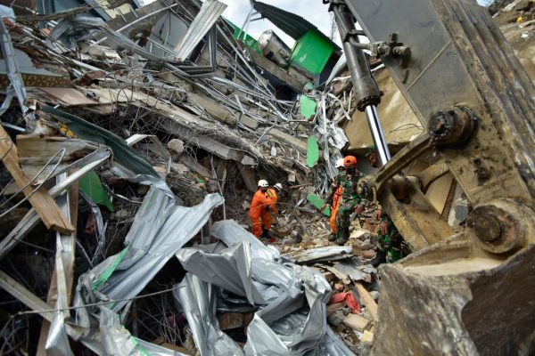 Los equipos de rescate buscan sobrevivientes en el sitio de un edificio colapsado en Mamuju el 16 de enero de 2021, un día después de que un terremoto de magnitud 6.2 sacudiera la isla indonesia de Sulawesi. (Foto de Hariandi Hafid / AFP a través de Getty Images)