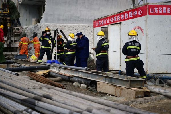 Esta foto tomada el 20 de enero de 2021 muestra a miembros de un equipo de rescate trabajando en el sitio de la explosión de una mina de oro donde 22 mineros están atrapados bajo tierra en Qixia, en la provincia de Shandong, en el este de China. (Foto de STR / AFP a través de Getty Images)