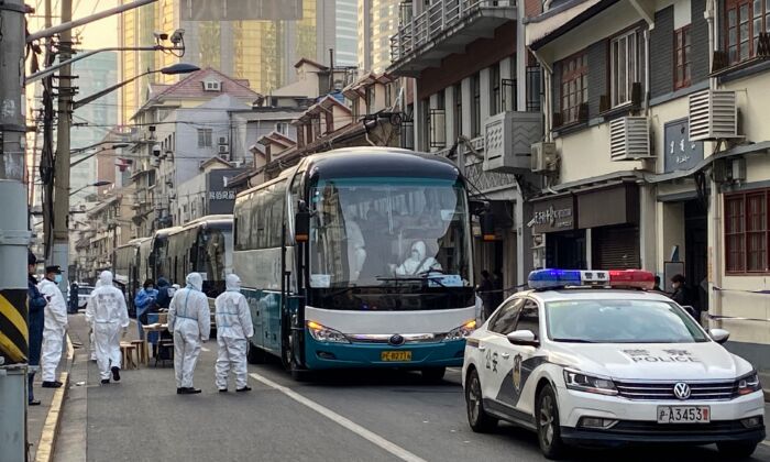 La policía y trabajadores organizan autobuses para trasladar a todos los residentes de un barrio del distrito de Huangpu a los centros de cuarentena, en Shanghai, el 21 de enero de 2021. (AFP a través de Getty Images)