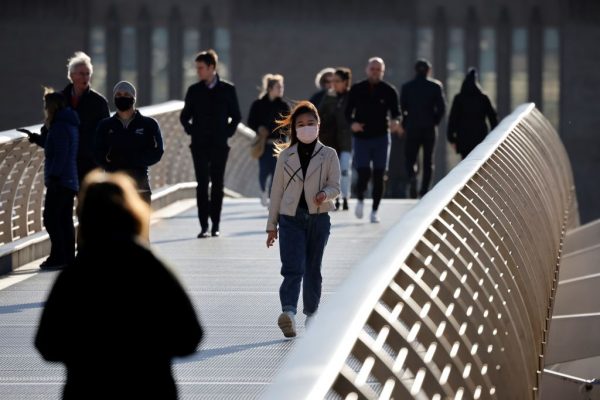 La gente cruza el puente Millennium en el centro de Londres mientras Gran Bretaña sufre su tercer bloqueo nacional debido al covid-19 el 21 de enero de 2021 (Foto de Tolga Akmen / AFP a través de Getty Images)