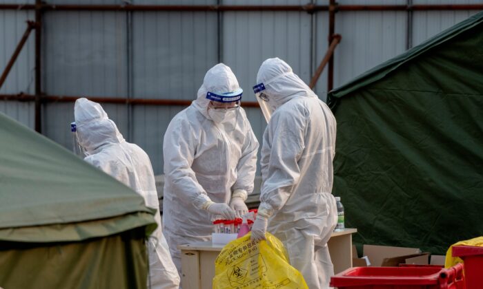 Los trabajadores médicos se encuentran en un sitio de prueba de COVID-19 en Beijing, China, el 23 de enero de 2021. (Noel Celis/AFP a través de Getty Images)