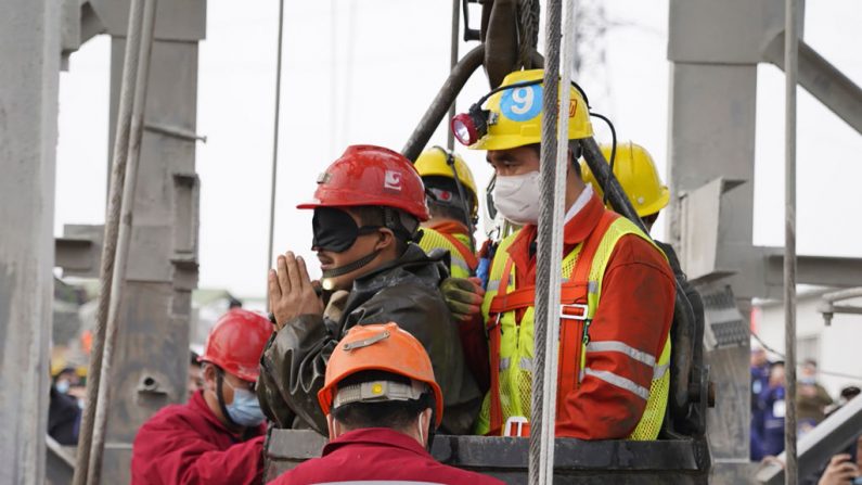 Uno de los veintidós mineros chinos con un parche negro se salva de cientos de metros bajo tierra, donde habían estado atrapados durante dos semanas luego de la explosión de una mina de oro en Qixia, en la provincia de Shandong, en el este de China, el 24 de enero de 2021. (STR/CNS/AFP a través de Getty Images)