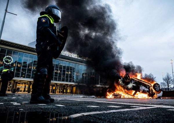 Un automóvil fue incendiado frente a la estación de tren, el 24 de enero de 2021 en Eindhoven, Países Bajos, luego de una manifestación de varios cientos de personas contra la política de toque de queda por el covid-19. (Foto de Rob Engelaar / ANP / AFP a través de Getty Images)