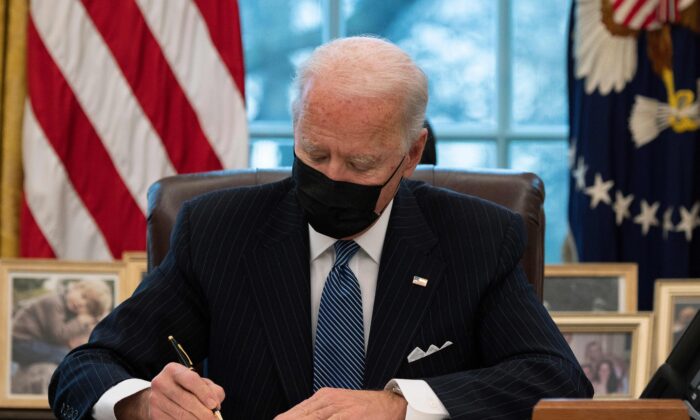 El presidente Joe Biden firma una orden ejecutiva que revierte la prohibición, de la era Trump, al servicio en el ejército de las personas transgénero, en la Oficina Oval de la Casa Blanca, el 25 de enero de 2021. (Jim Watson/AFP a través de Getty Images)