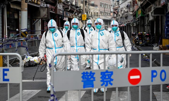 Los trabajadores de la salud salen de un área bloqueada después de rociar desinfectante en el distrito de Huangpu, Shanghai, China, el 27 de enero de 2021. (STR/AFP a través de Getty Images)