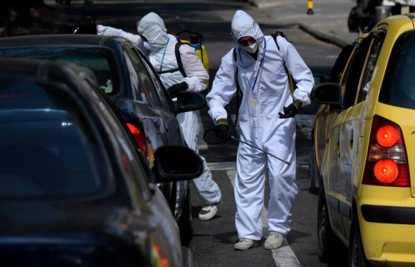 Los hermanos colombianos Jairo y Oscar Bernal trabajan en un semáforo desinfectando autos como una forma de ganarse la vida debido a la pandemia en Bogotá, Colombia, el 28 de enero de 2021. (Foto de Raul Arboleda / AFP a través de Getty Images)