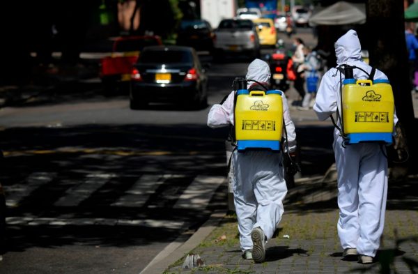 Los hermanos colombianos Jairo y Oscar Bernal trabajan en un semáforo desinfectando autos como una forma de ganarse la vida debido a la pandemia en Bogotá, Colombia, el 28 de enero de 2021. (Foto de Raul Arboleda / AFP a través de Getty Images)