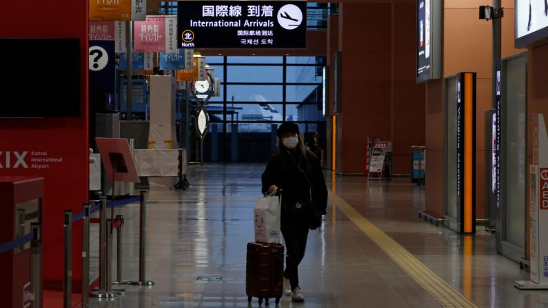 Una pasajera con mascarilla mientras camina por la sala de llegadas casi vacía en el Aeropuerto Internacional de Kansai el 27 de diciembre de 2020 en Osaka, Japón. (Foto de Buddhika Weerasinghe / Getty Images)