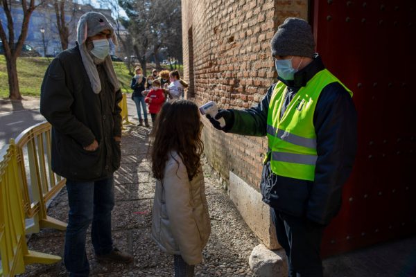 Un trabajador utiliza un termómetro infrarrojo puntual para medir la temperatura corporal de las personas que visitan los Reyes Magos en la plaza de toros de Aranjuez como alternativa a la tradicional Desfile en un intento por observar las medidas de seguridad sanitaria contra el covid-19 el 05 de enero de 2021 en Aranjuez, España. (Foto de Pablo Blazquez Dominguez / Getty Images)