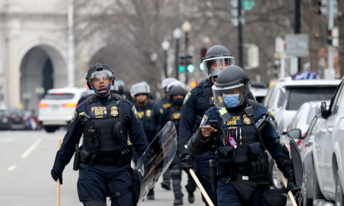 Agentes de policía con equipo antidisturbios caminan hacia el Capitolio de los EE. UU. mientras un grupo de manifestantes irrumpe en el edificio del Capitolio en Washington el 6 de enero de 2021. (Tasos Katopodis/Getty Images)