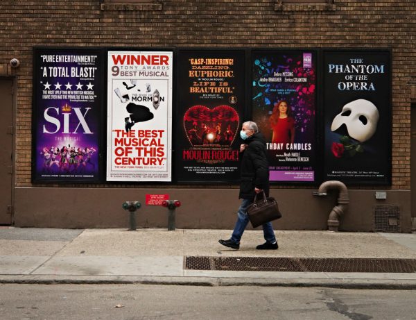 Una persona camina junto a los carteles de Broadway cerca de Times Square mientras los cines permanecen cerrados tras las restricciones impuestas para frenar la propagación del covid-19 el 15 de enero de 2021 en la ciudad de Nueva York (EE.UU.). (Foto de Cindy Ord / Getty Images)